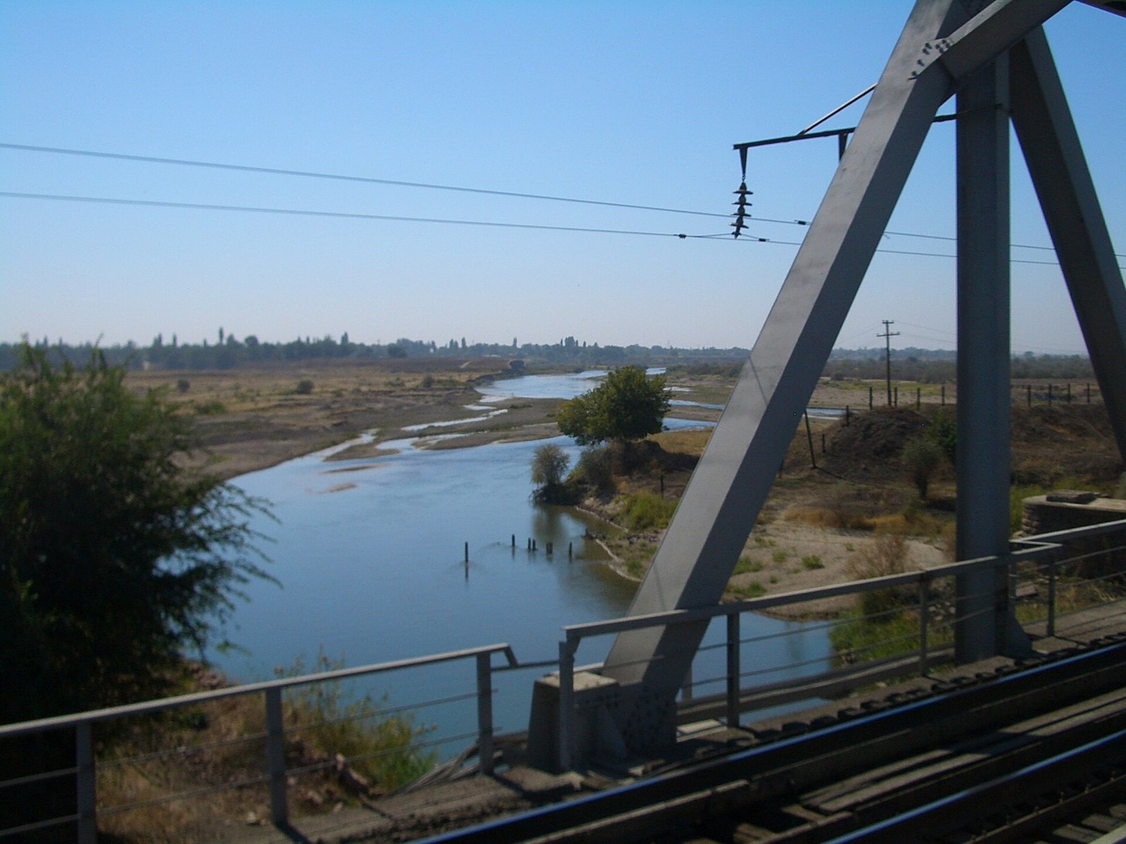 The Chu crossing the plain below a railway bridge