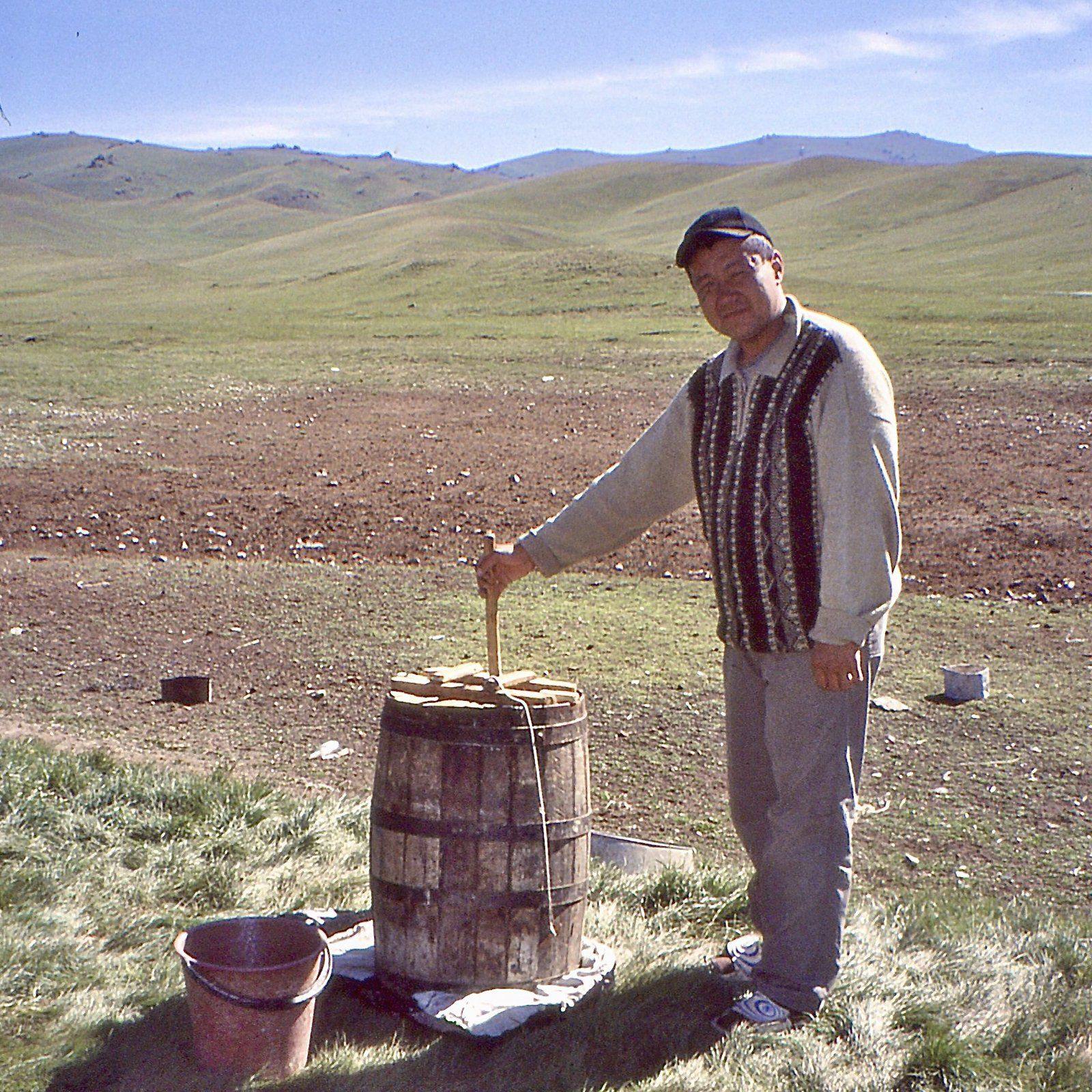 Churning kymyz on a summer pasture